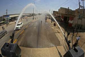 سكان البصرة يستخدمون خراطيم المياه الخاصة بقوات مكافحة الشغب لتعقيم الشوارع